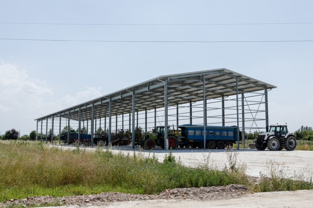 Struttura agricola, vista esterna da destra con macchine agricole all'interno
