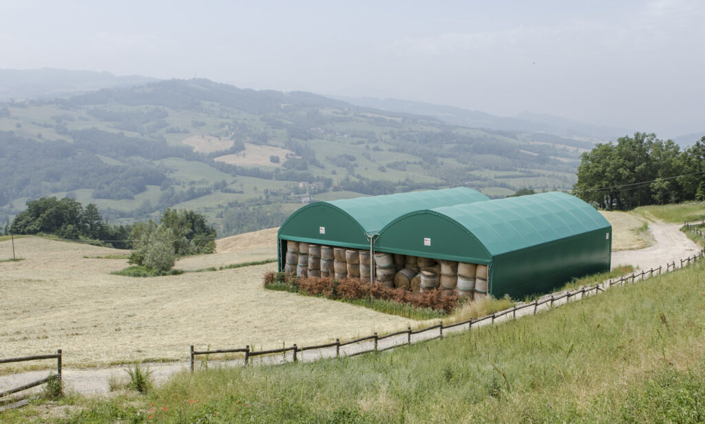 Vertical tunnel, vista esterna dall'alto di due strutture vicine piene di fieno